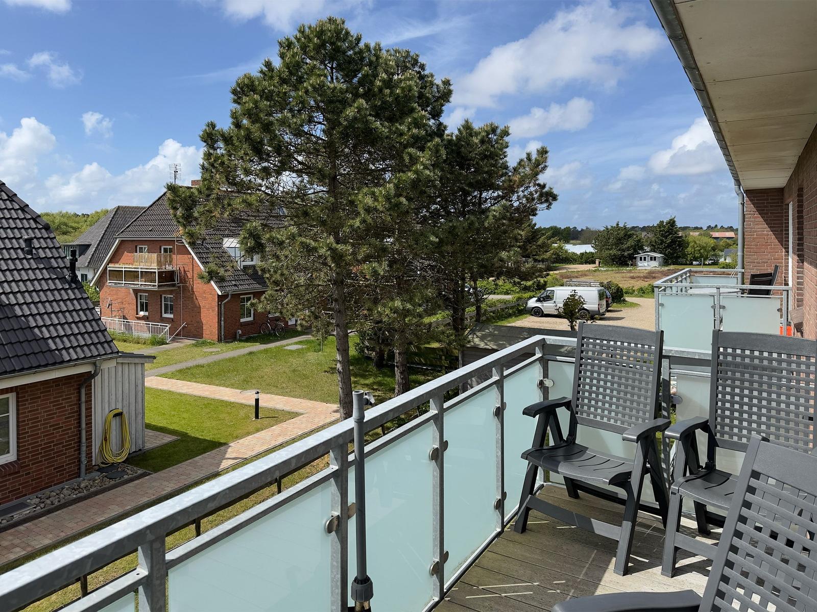 Terrace with chairs and view of green areas and houses