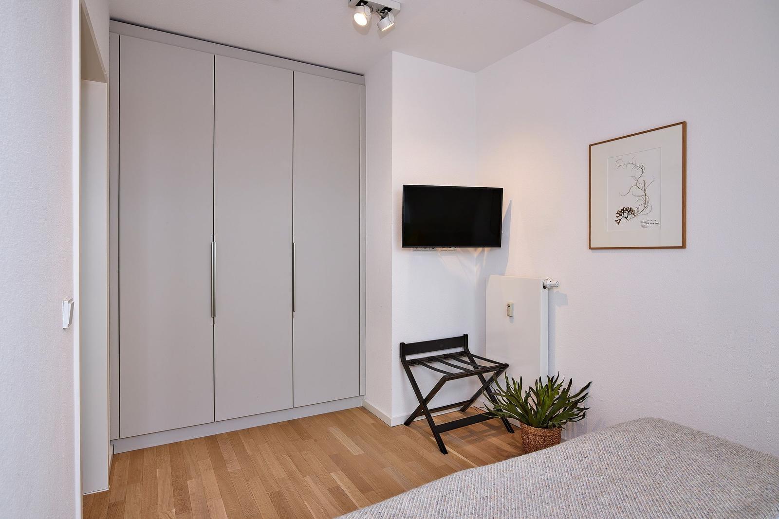 Schlafzimmer mit Kleiderschrank im lalo18, Hauptstraße 9, Lüttjeod Apartmentvilla 18 auf Langeoog
