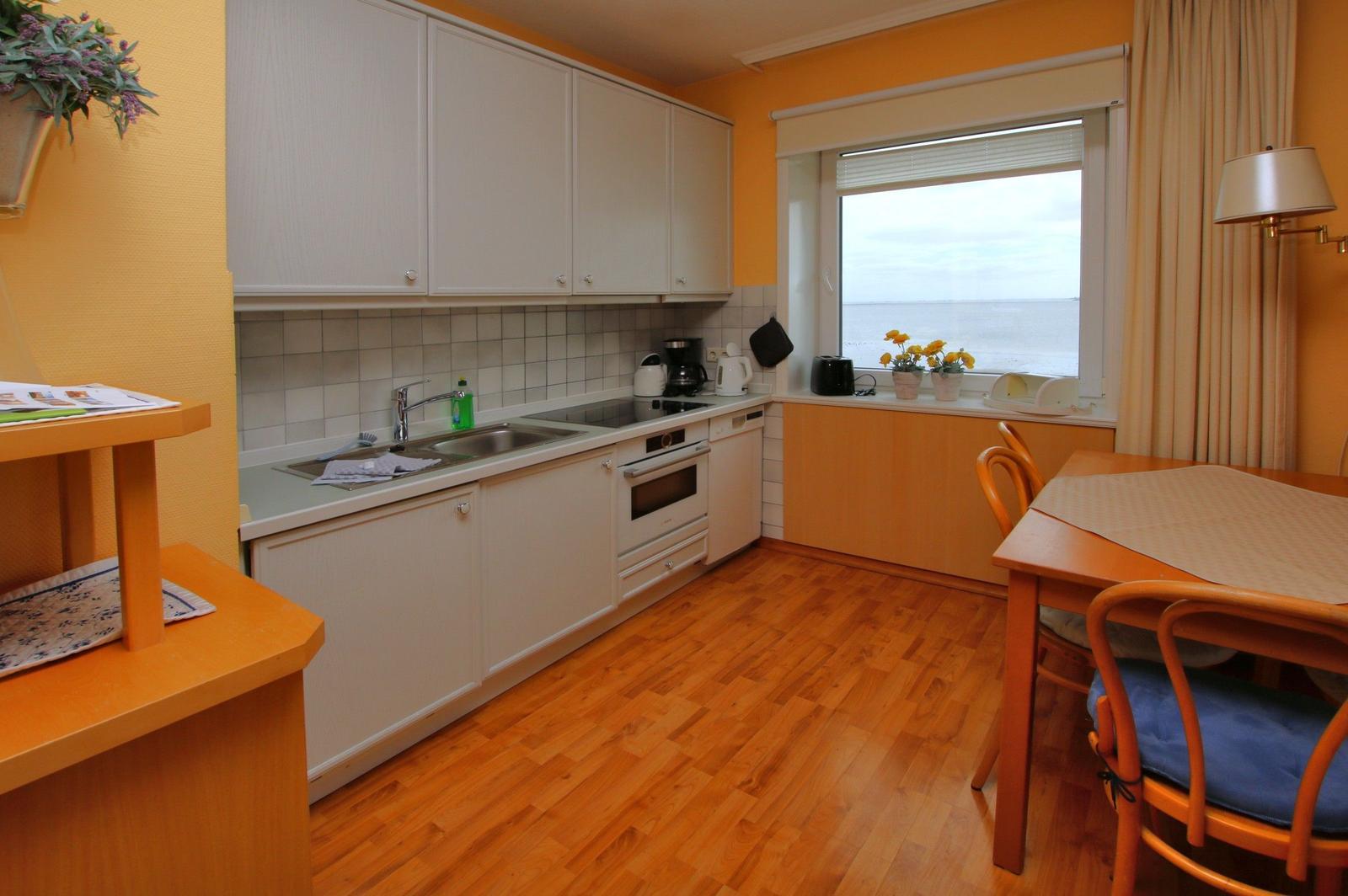 Küche mit Essbereich, Fenster mit Meerblick und Holzboden.
