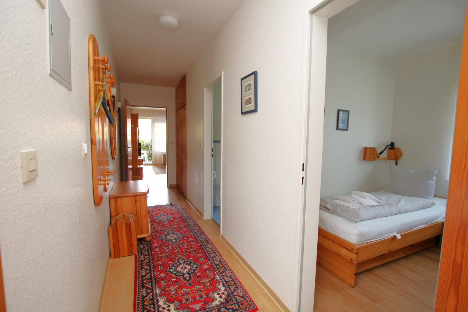 Flur mit Teppich und Schlafzimmer mit Holzbett