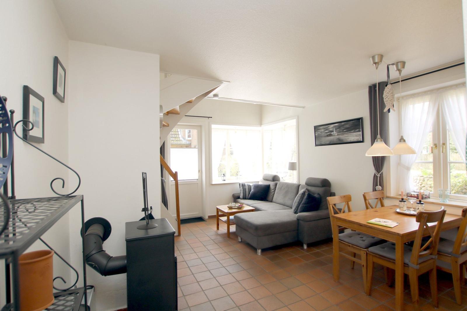 Wohn- und Essbereich mit Sofa, Esstisch und Treppenaufgang.