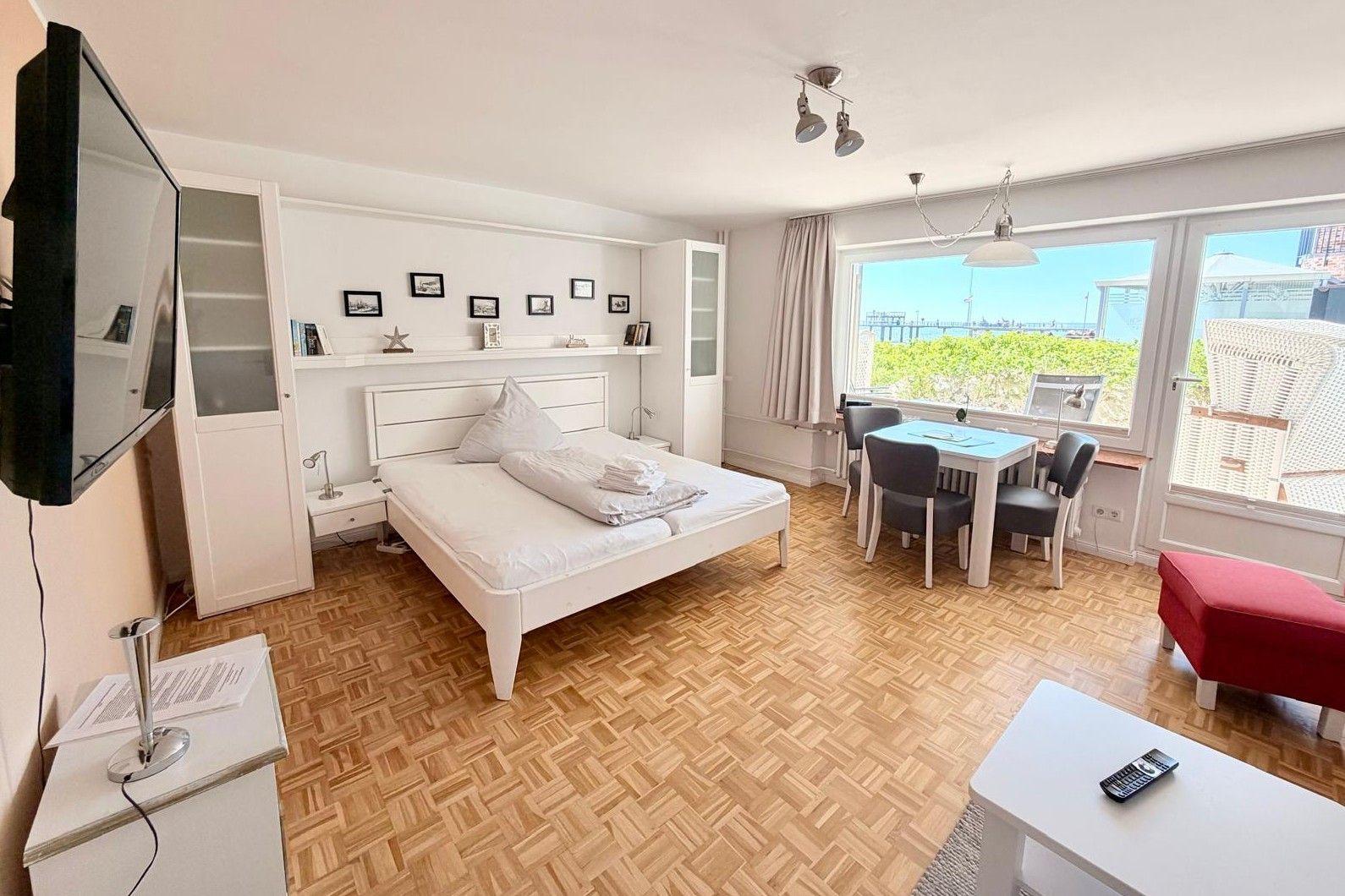 A bedroom with harbor view. It has a bed, a table and a TV.