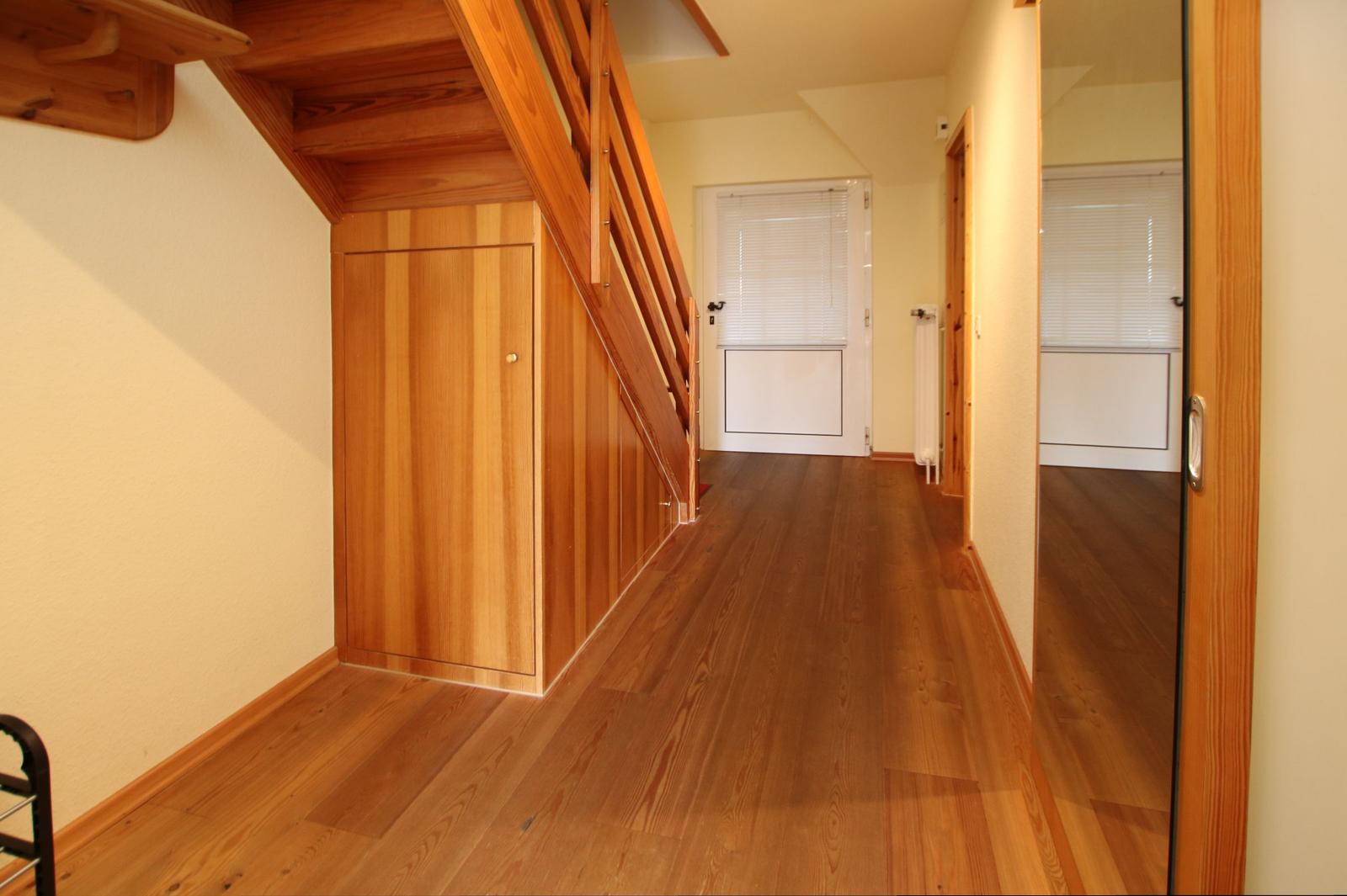 Hausflur mit Holzboden, Treppe und Tür