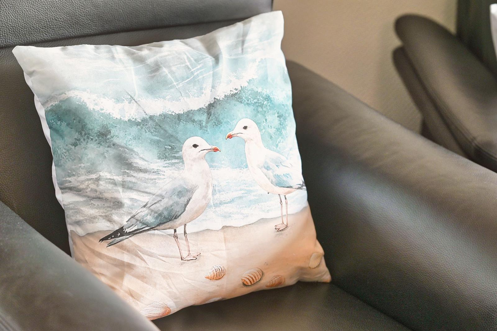 Kissen mit Möwenmotiv auf dunklem Sofa