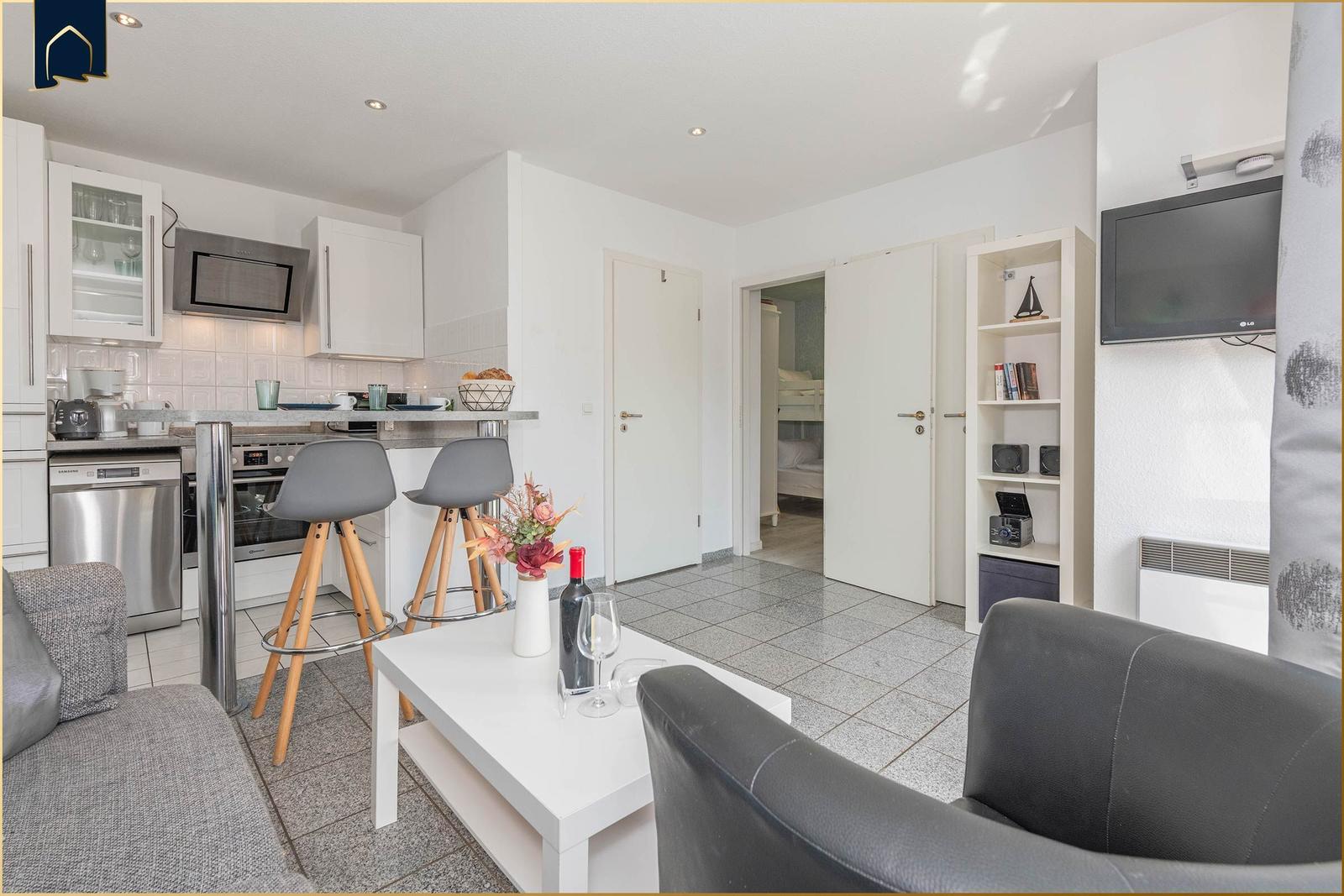Wohnung mit Küche, Wohnbereich und Schlafzimmer. Flur mit Tür zum Schlafzimmer.