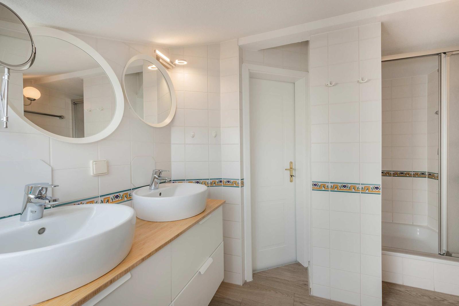 Badezimmer mit zwei Waschbecken, Spiegeln und Dusche