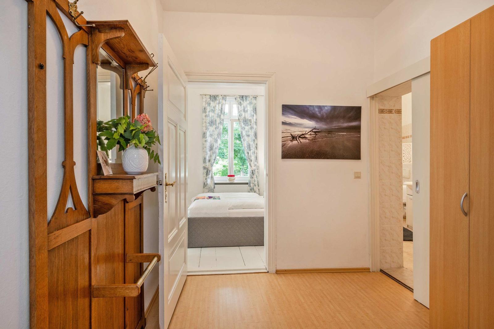 Schlafzimmer mit Blick auf Garten. Holzfußboden und Wandbild.