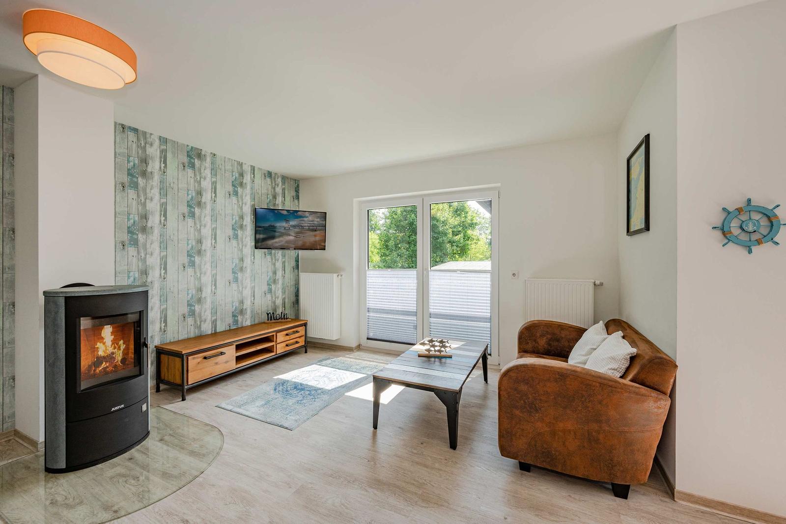 Wohnzimmer mit Kamin, Sofa, Couchtisch und TV an Holzwand.