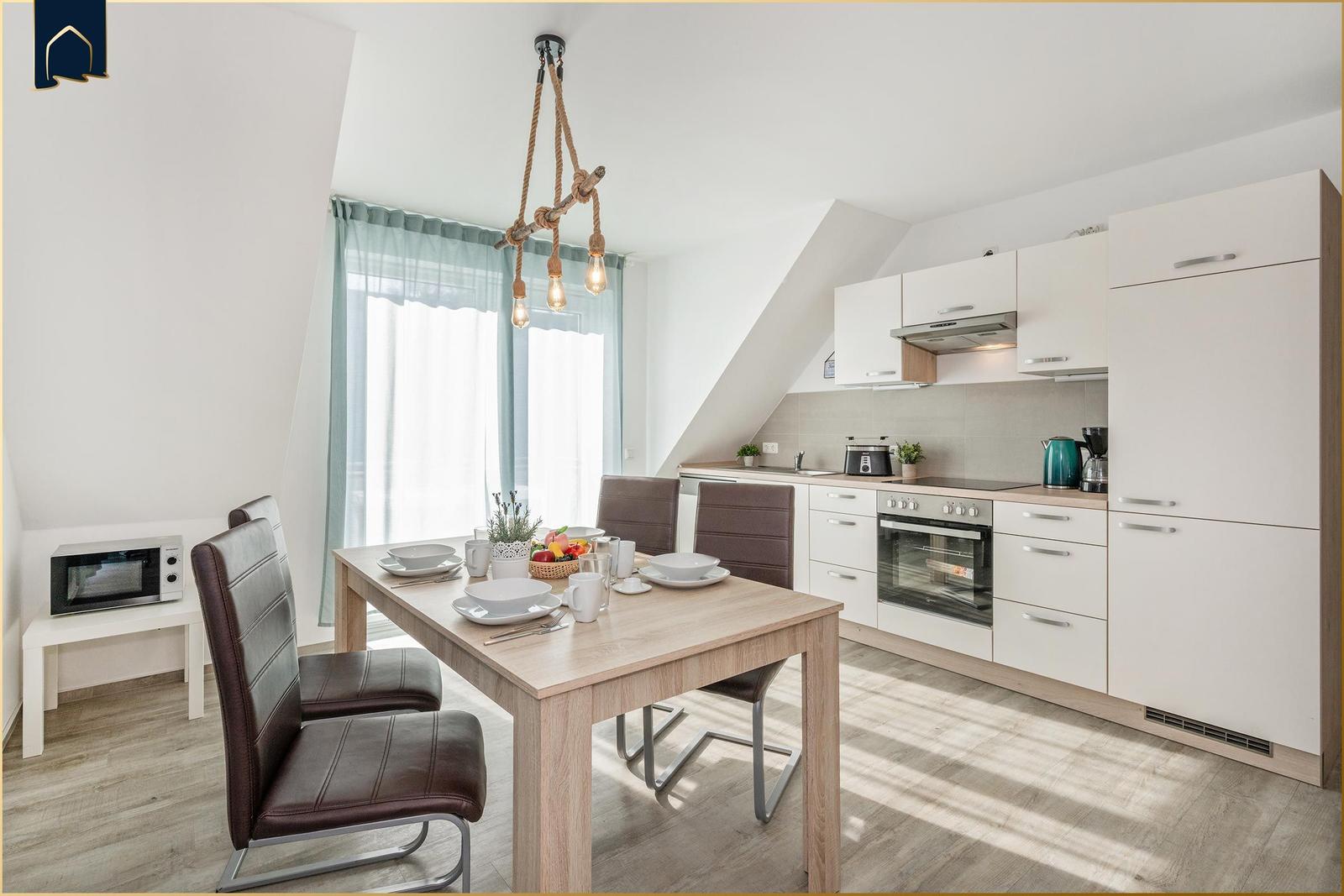 Küche und Essbereich mit Tisch, Stühlen und Fenster