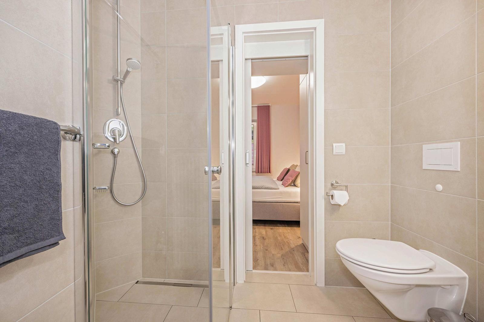 Bad mit Dusche, Toilette und Blick in Schlafzimmer