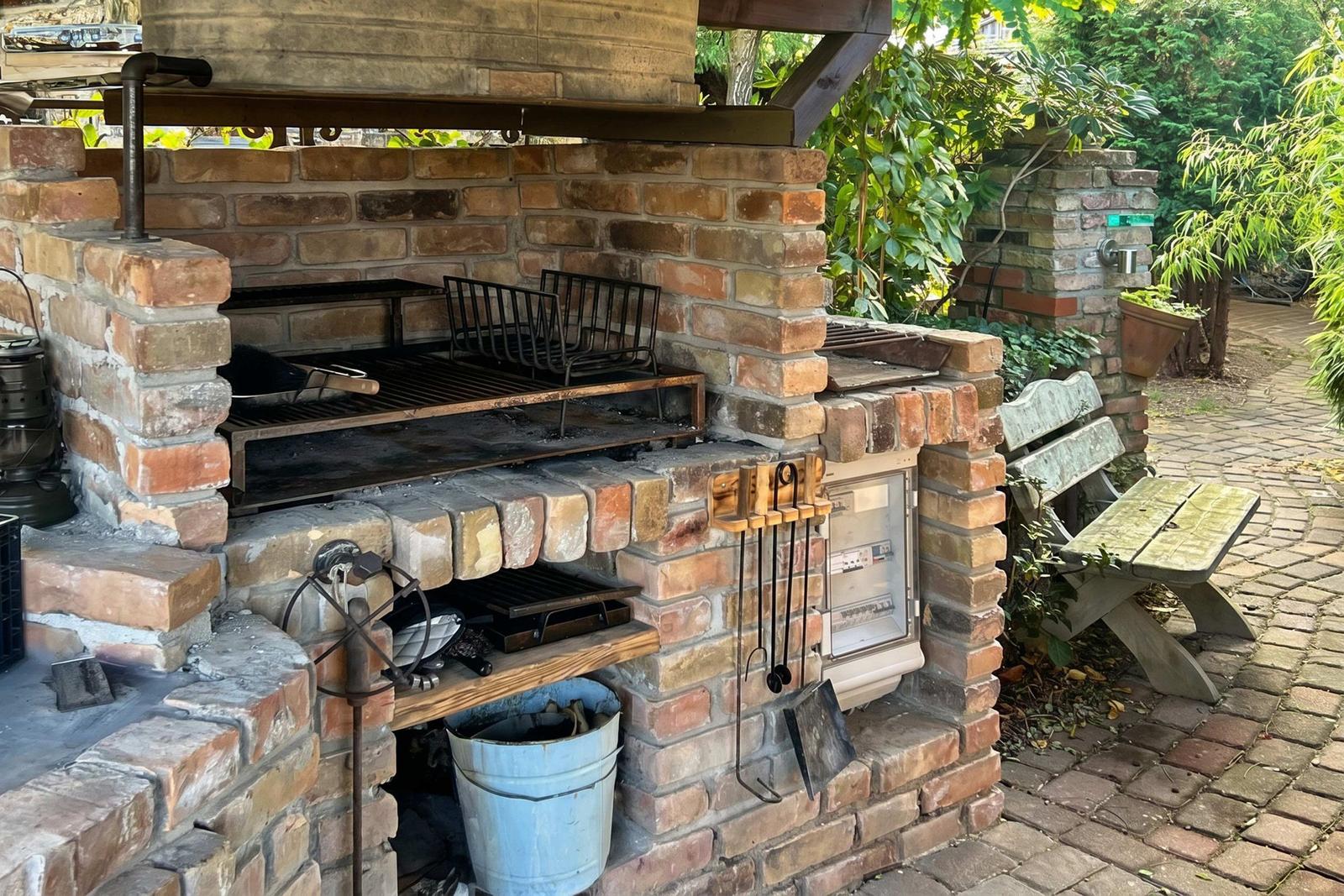 Steinofen mit Grill und Zubehör im Außenbereich