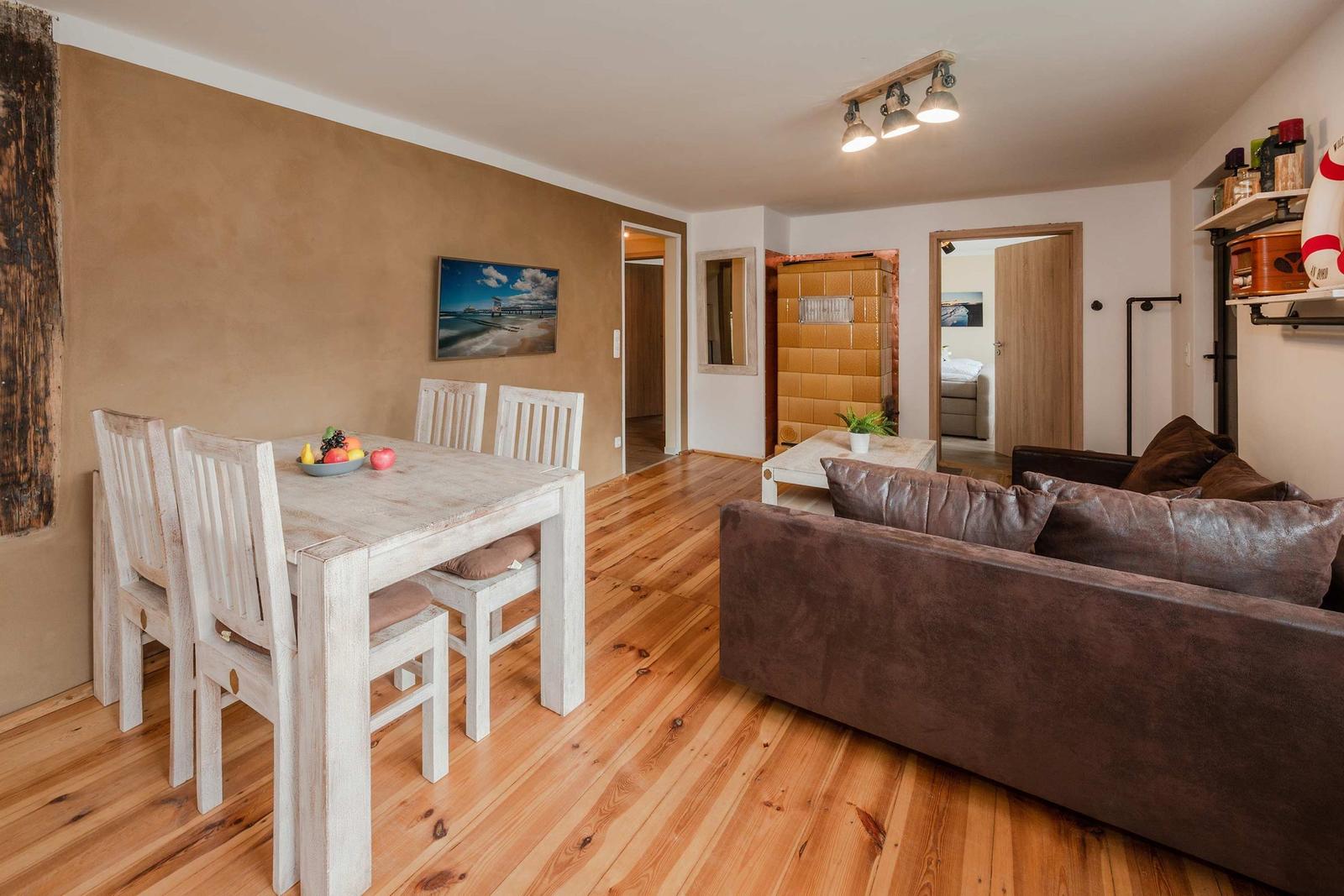 Essbereich mit Tisch und Stühlen. Wohnbereich mit Sofa und Holzboden.
