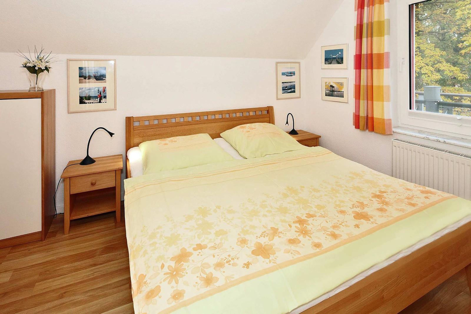 Schlafzimmer mit Doppelbett, Holzmöbel und Fenster mit Blick.