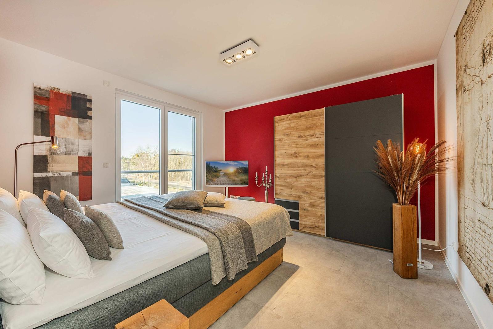 Schlafzimmer mit Bett, Fenster, Kleiderschrank und Wanddekoration.