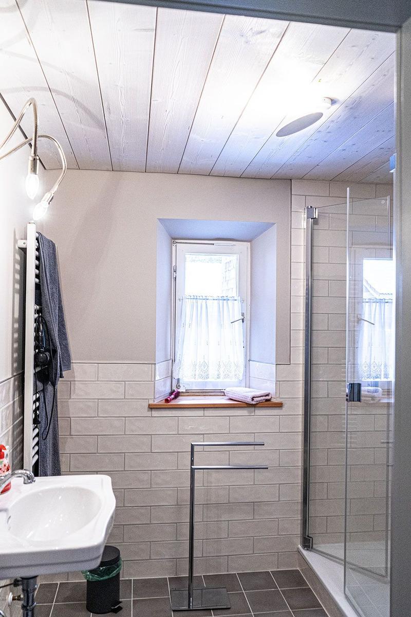 Bathroom with shower, sink, and window