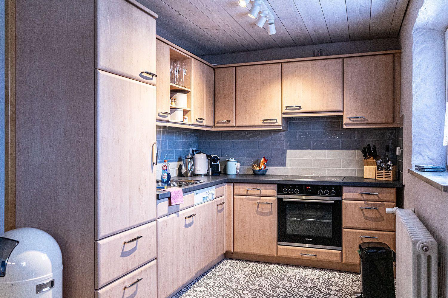 Kitchen with wooden cabinets, stainless steel sink, and built-in oven.