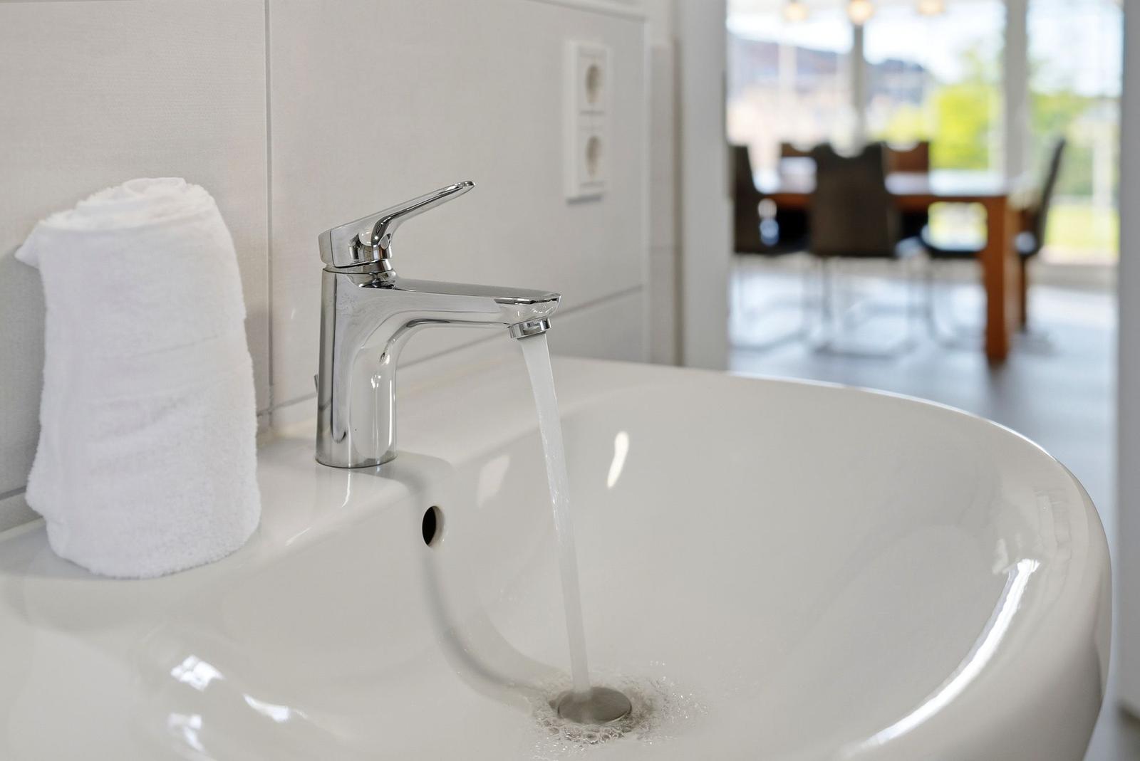 Waschbecken mit Wasserhahn und Handtuch im Badezimmer