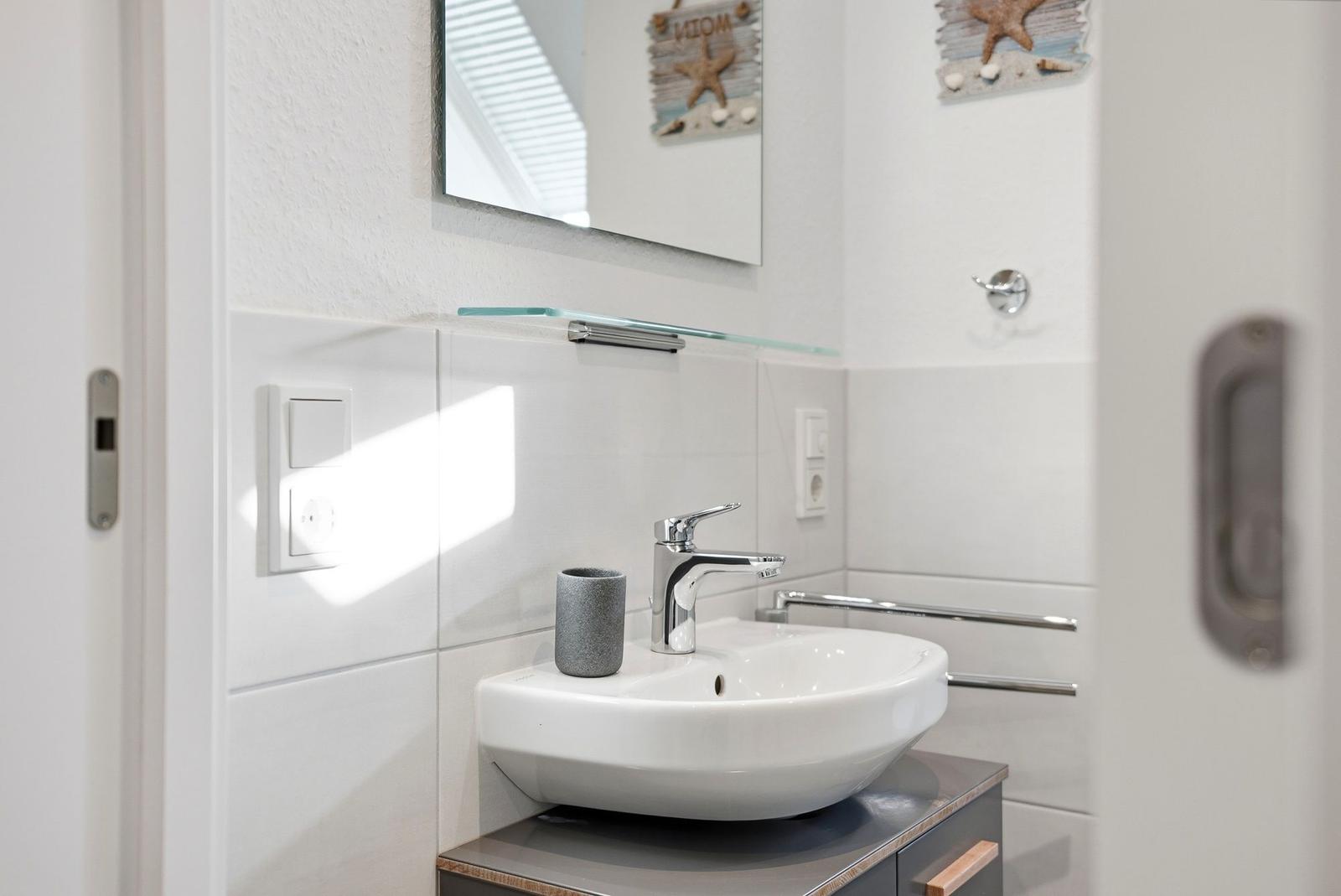 Waschbecken mit Spiegel und Seestern-Dekoration an der Wand