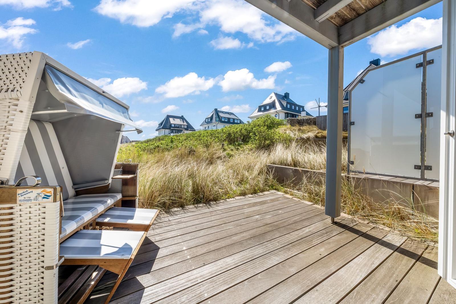 Terrasse mit Strandkorb und Blick auf Dünen und Häuser
