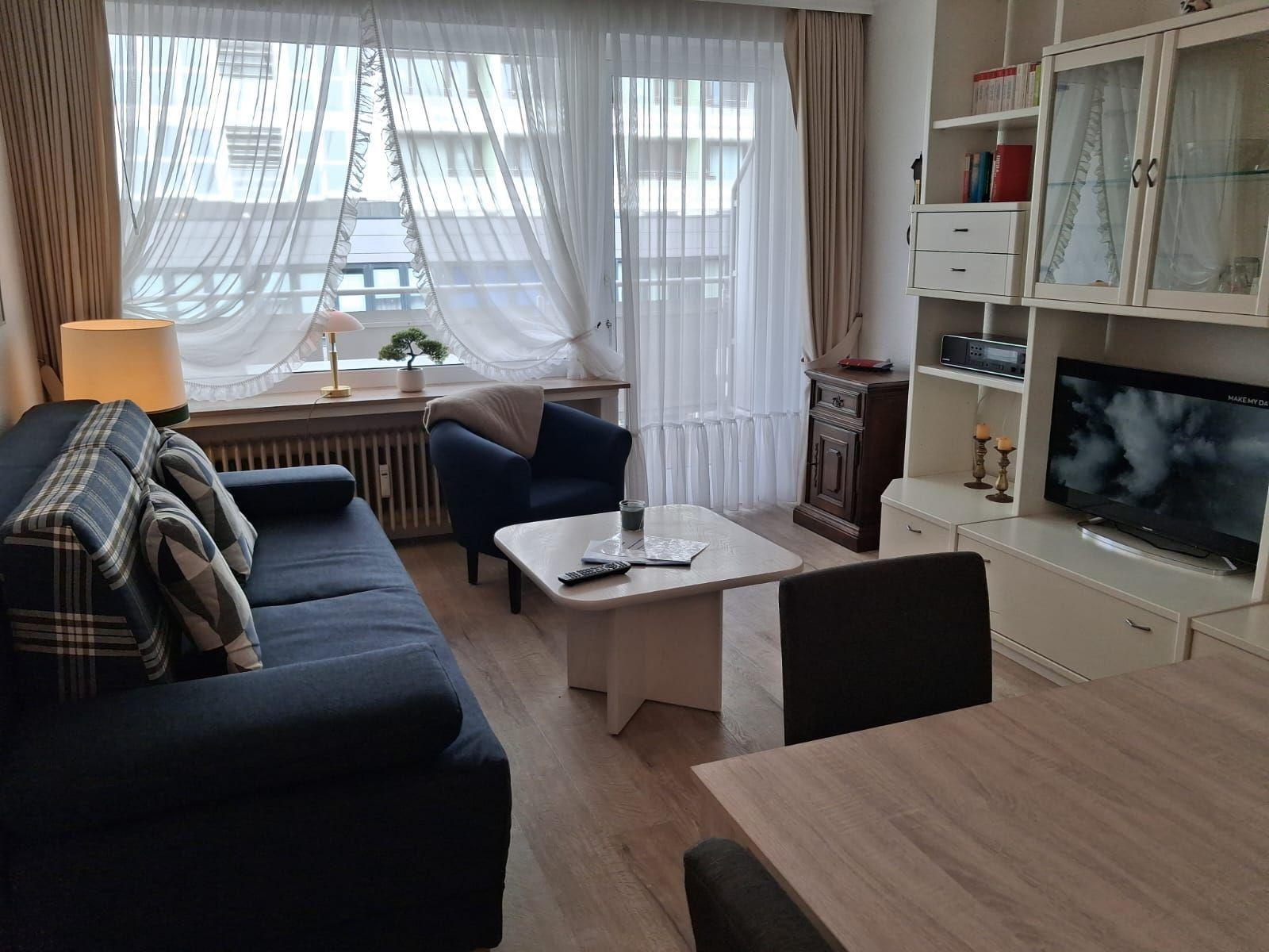 Wohnzimmer mit Sofa, Sessel, Couchtisch und TV-Möbel