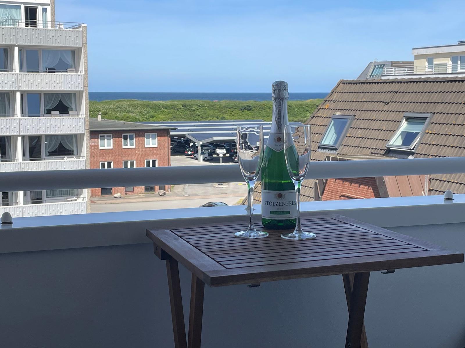 Auf der Terrasse steht ein Tisch mit einem Sektglas und einer Flasche Stolzenfels.