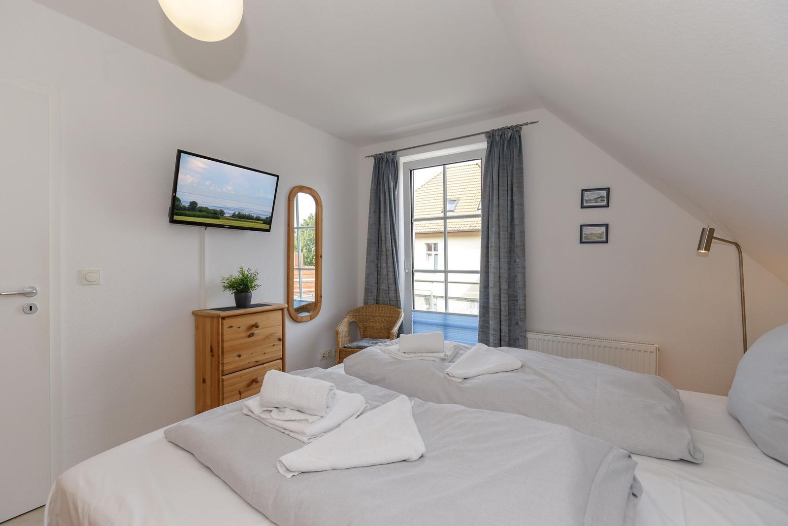 Zimmer mit Doppelbett, Fernseher, Spiegel und Fenster mit Blick.