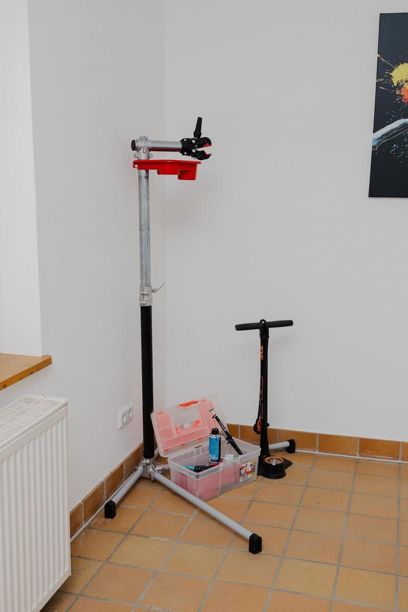 Radreparaturset und Roller stehen in einem Raum mit Fliesenboden und Wandbild.