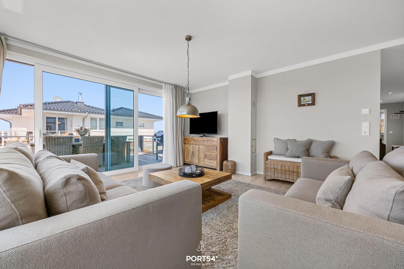 Wohnzimmer mit Sofa, Couchtisch und Blick auf Balkon.