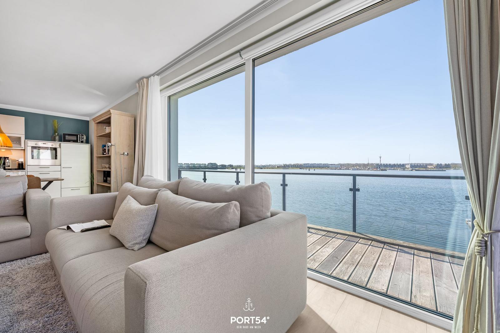 Wohnzimmer mit Sofa und Blick auf das Wasser