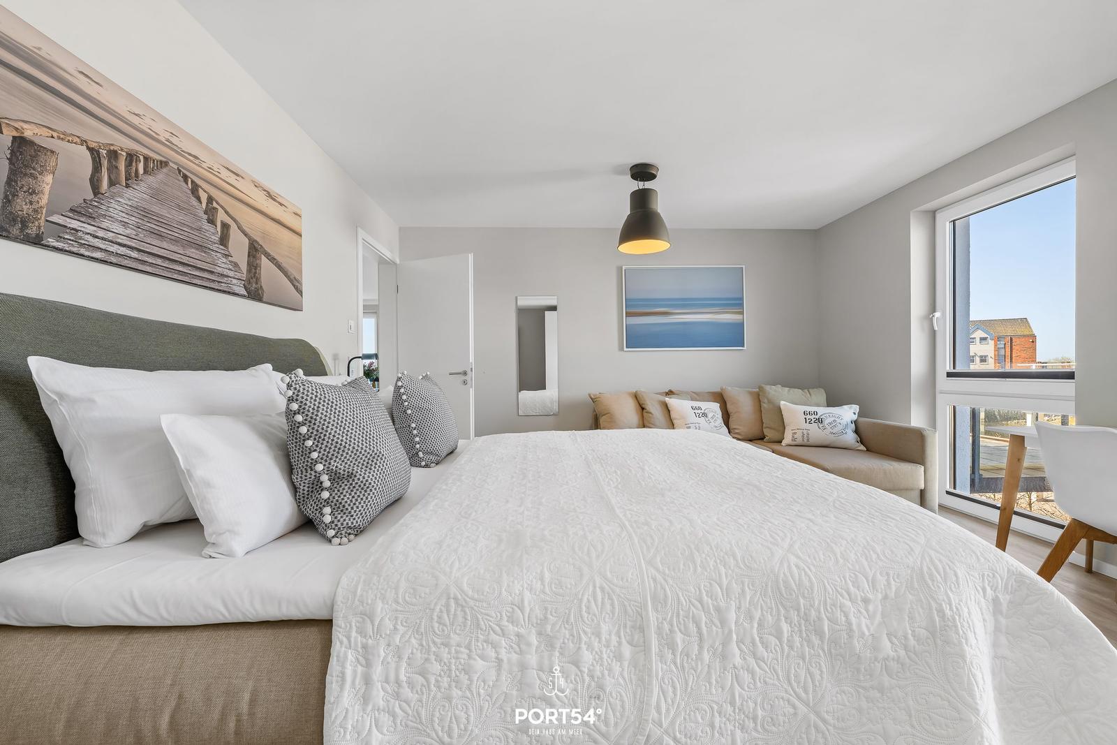 Schlafzimmer mit großem Bett, Fenster und Wandbild