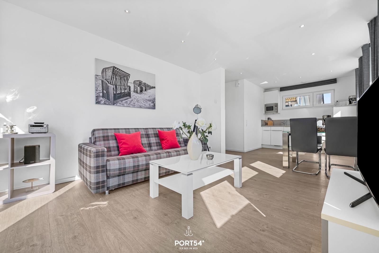 Wohn- und Essbereich mit Sofa, Couchtisch und Küchenbereich.