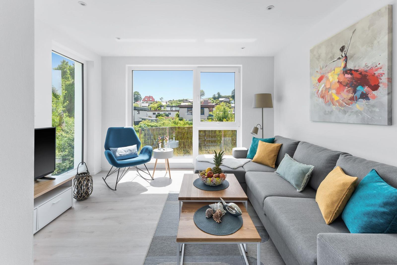 Living room with sofa, coffee table, and balcony view