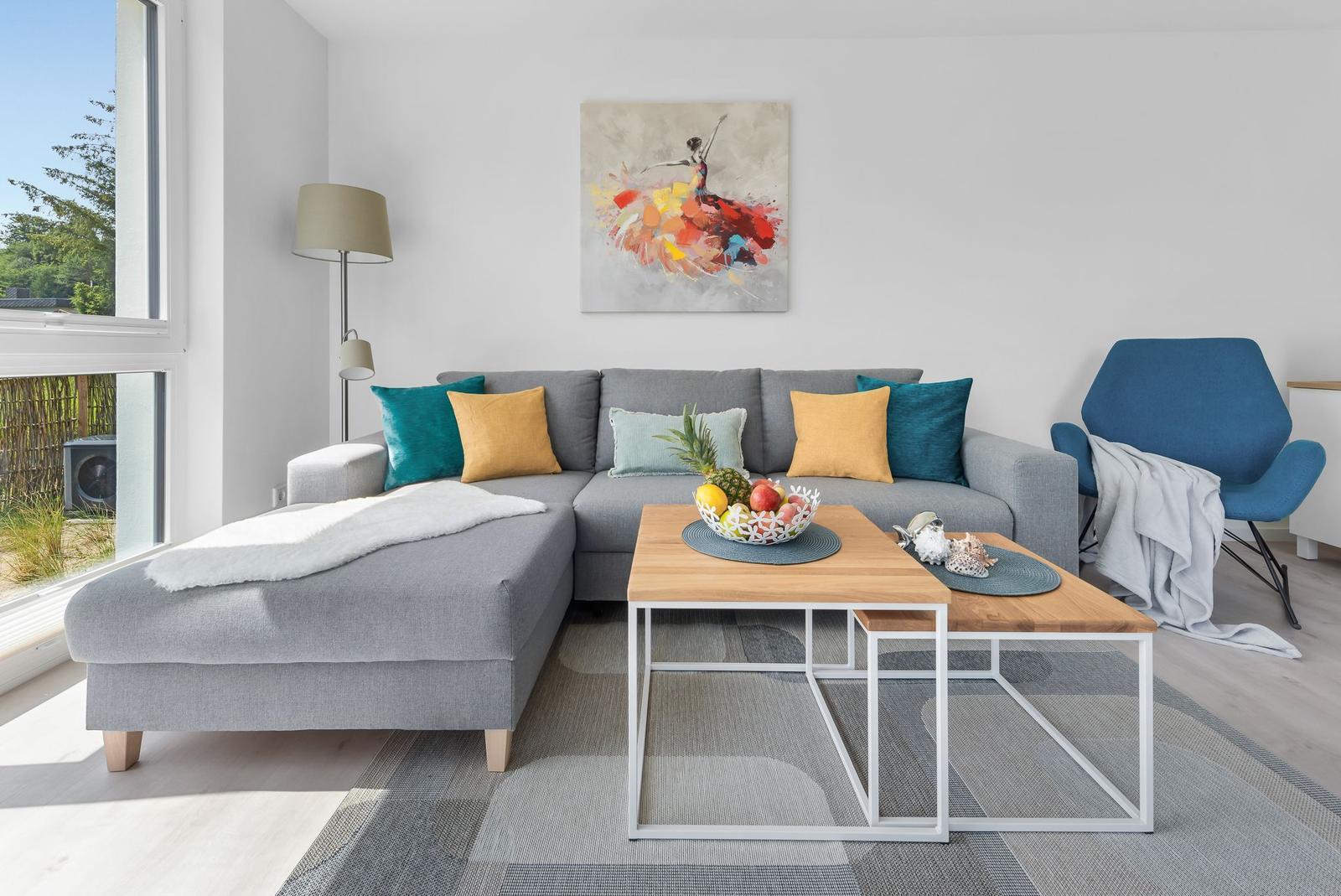 A living room with gray sofa, blue chair, and wooden table.