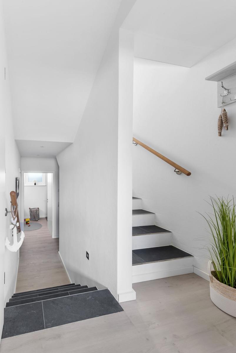 Bright entrance hall with stairs and plant