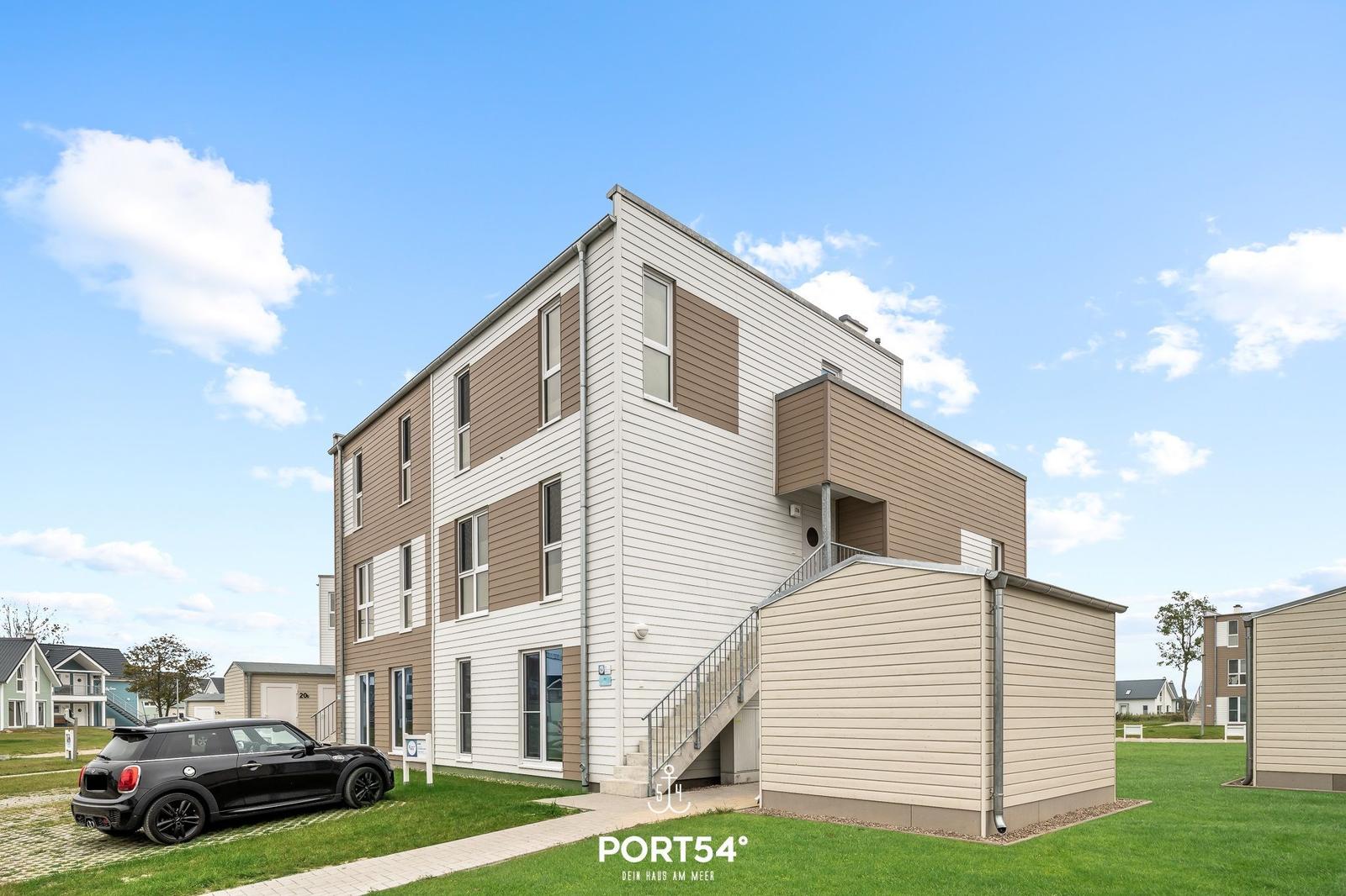 Modernes Mehrfamilienhaus mit Terrasse und Stellplatz im Grünen.