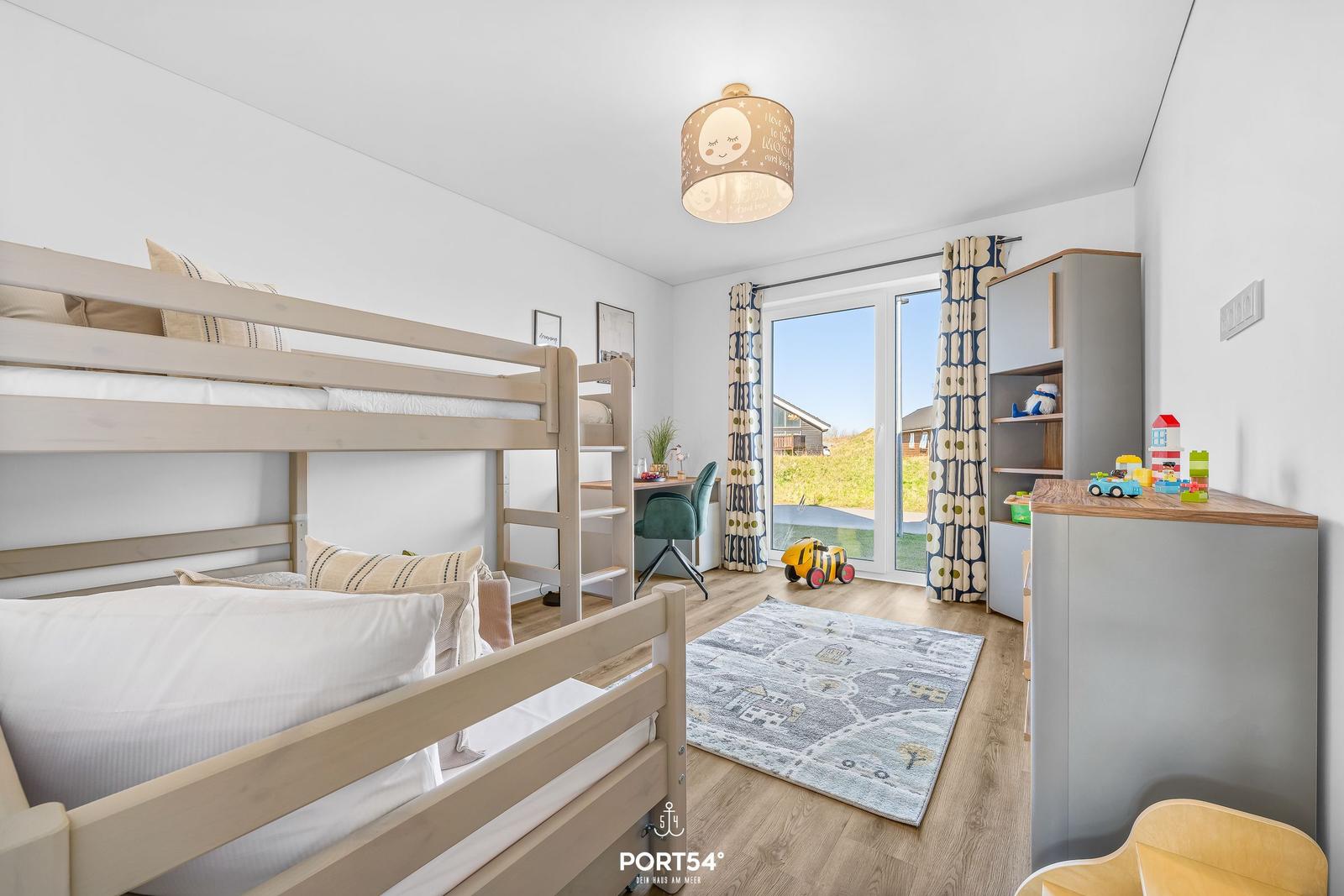 Kinderzimmer mit Doppelstockbett, Schreibtisch und Fensterblick auf Garten.