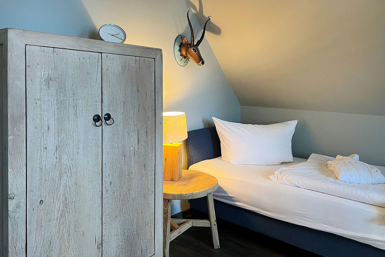 Schlafzimmer mit Bett, Kleiderschrank und Wanddekoration.