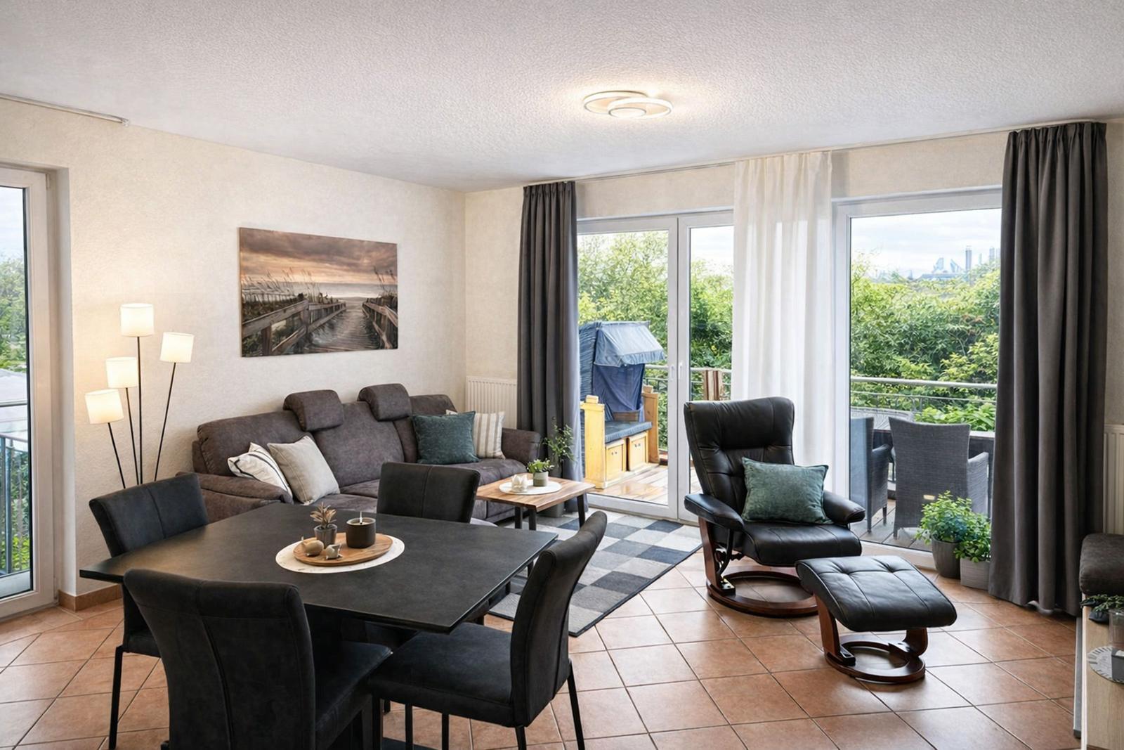Wohn- und Essbereich mit Balkon, Sofa, Esstisch und Sessel.