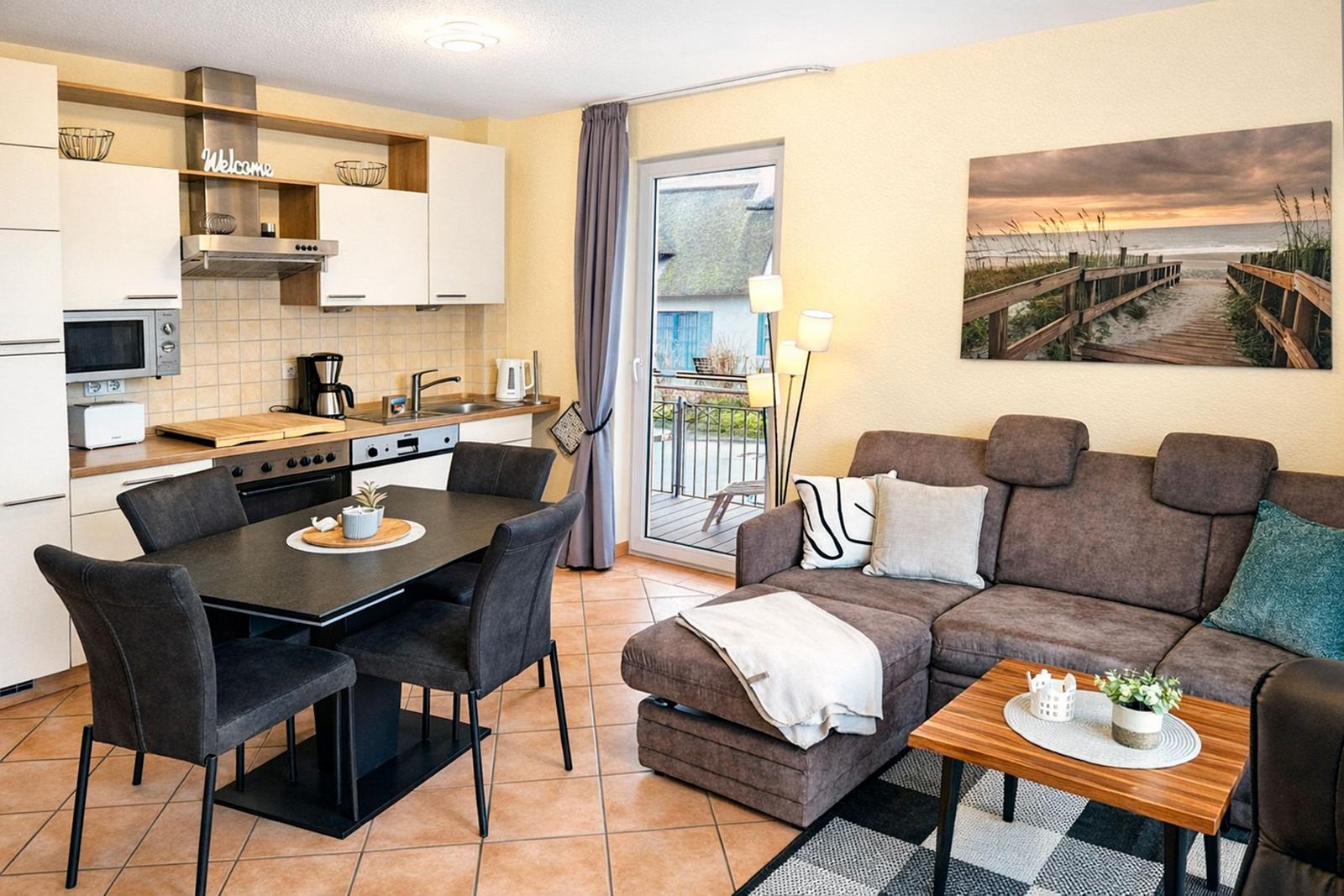 Wohnung mit Küche, Essbereich und Wohnzimmer mit Balkonansicht.