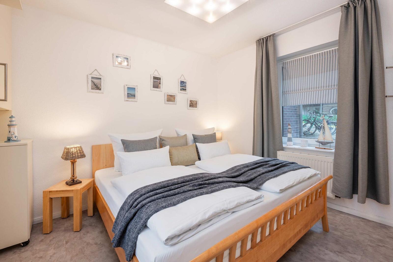 Ein Schlafzimmer mit einem Doppelbett, einem Nachttisch und einem Fenster mit Vorhängen.