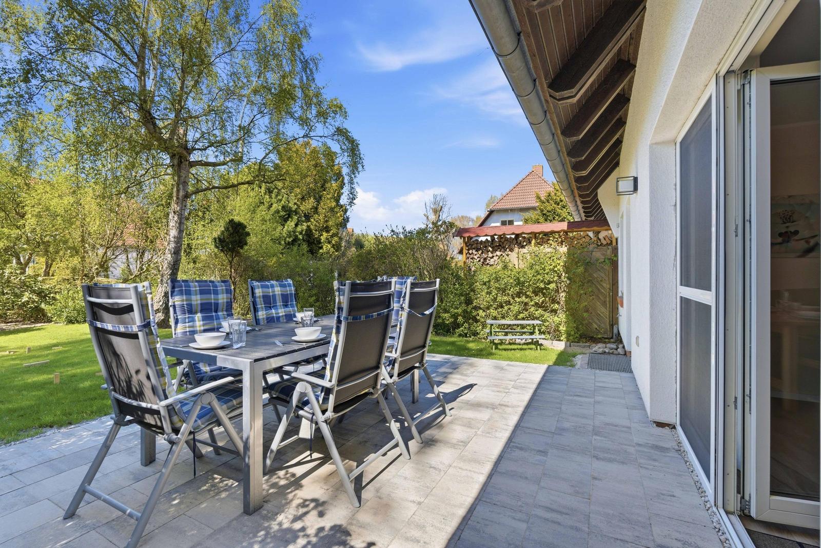 Terrasse mit Esstisch, Grill und Garten