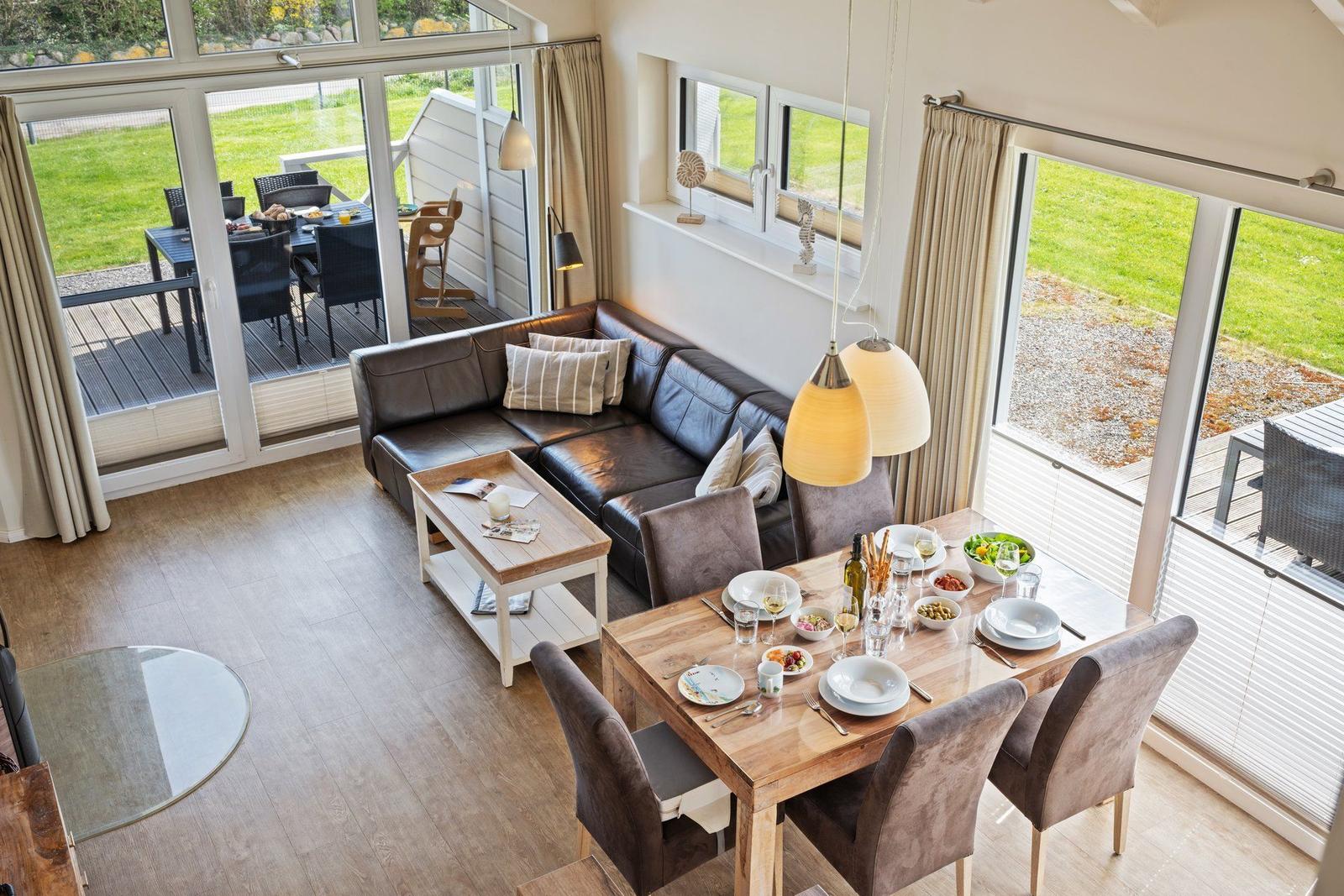 Wohn- und Essbereich mit Sofa, Tisch und Blick auf die Terrasse.