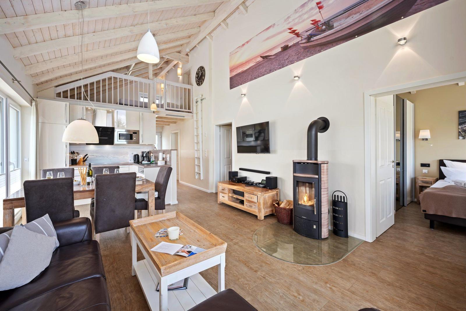 Wohnbereich mit Küche, Kamin und Schlafzimmer. Holzdecke und -boden.