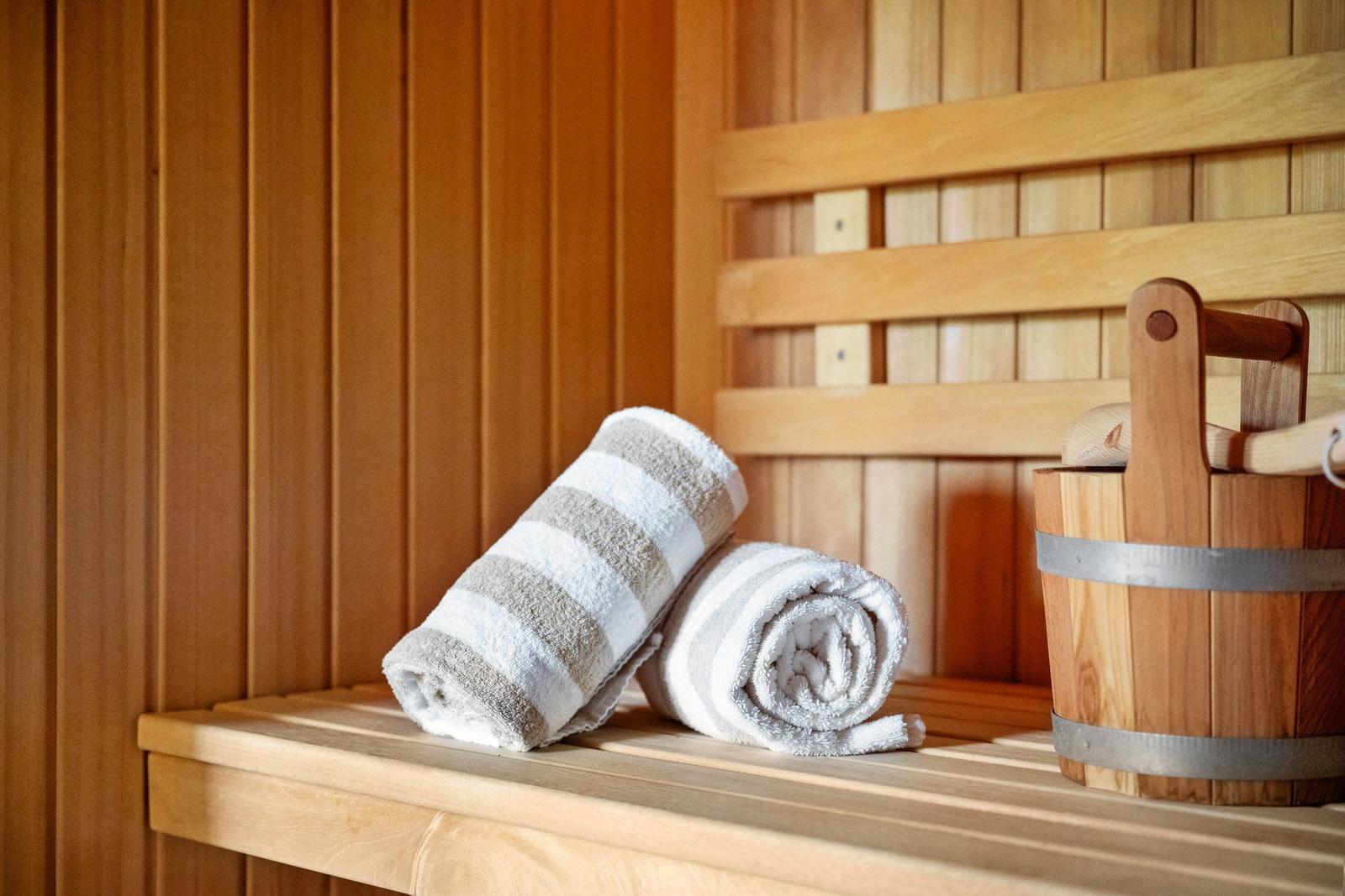 Sauna mit Holzbank, Handtuch und Eimer