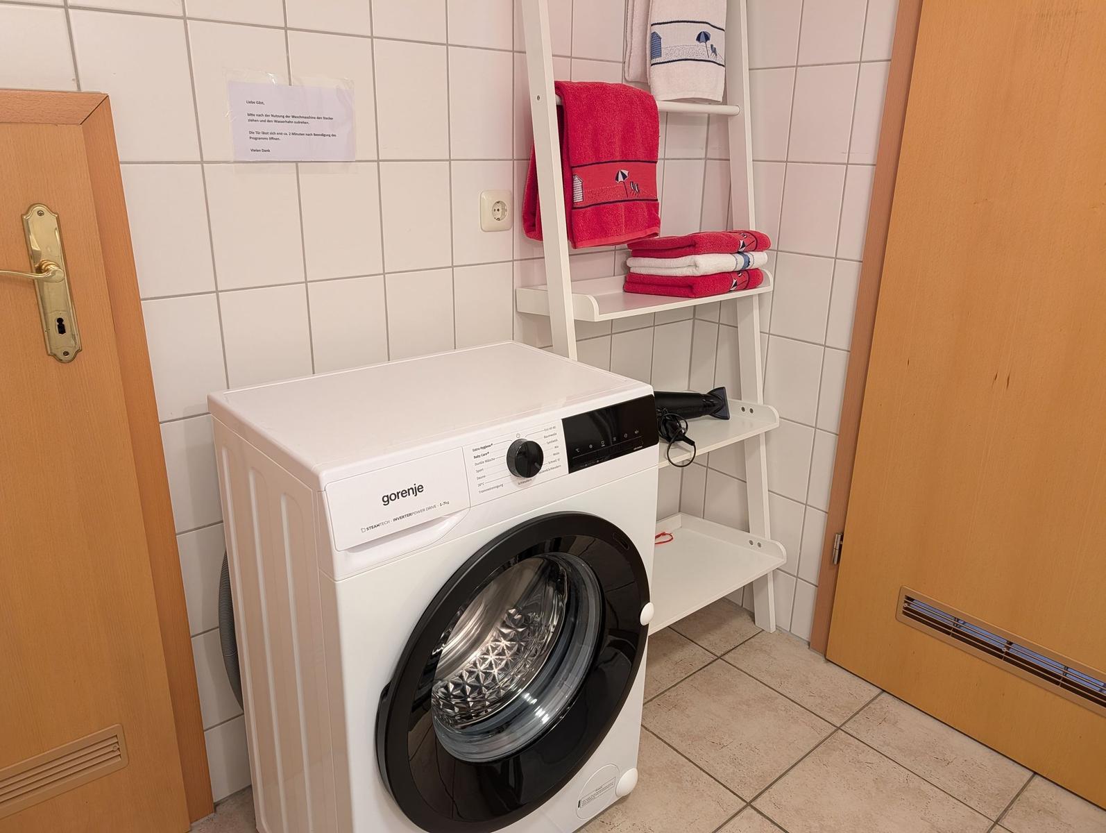 Waschmaschine mit Handtuchregal an Wand in Flur