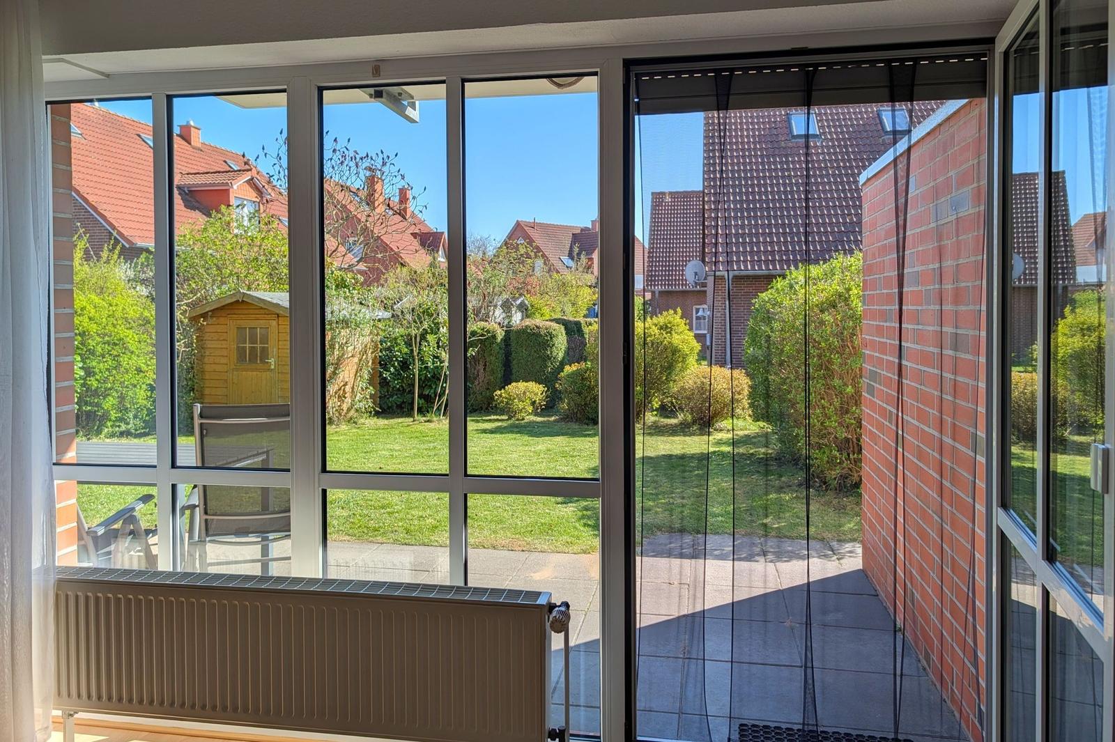 Terrasse mit Blick auf grünen Garten und Nachbarhäuser