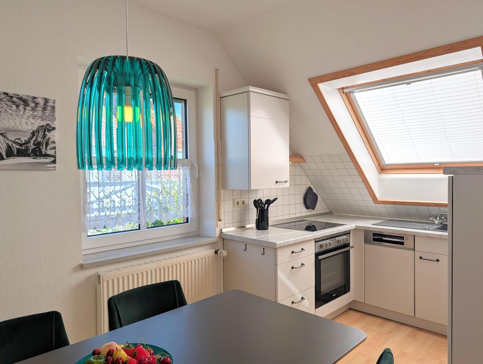 Kitchen with dining area, skylight, and modern lighting.