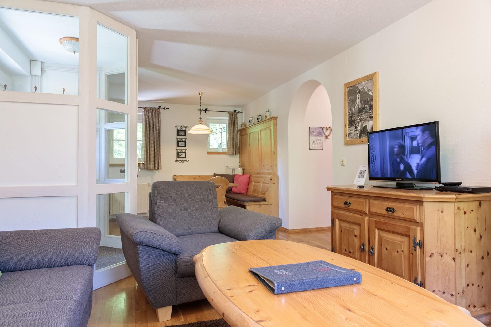 Living room with sofa, wooden table, and TV on sideboard