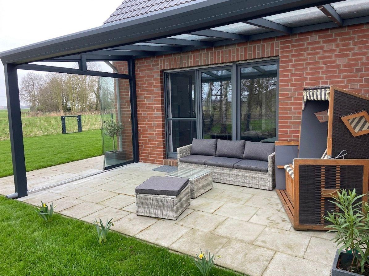 Terrasse mit Sitzgruppe, Pavillon und Blick auf grünen Garten.
