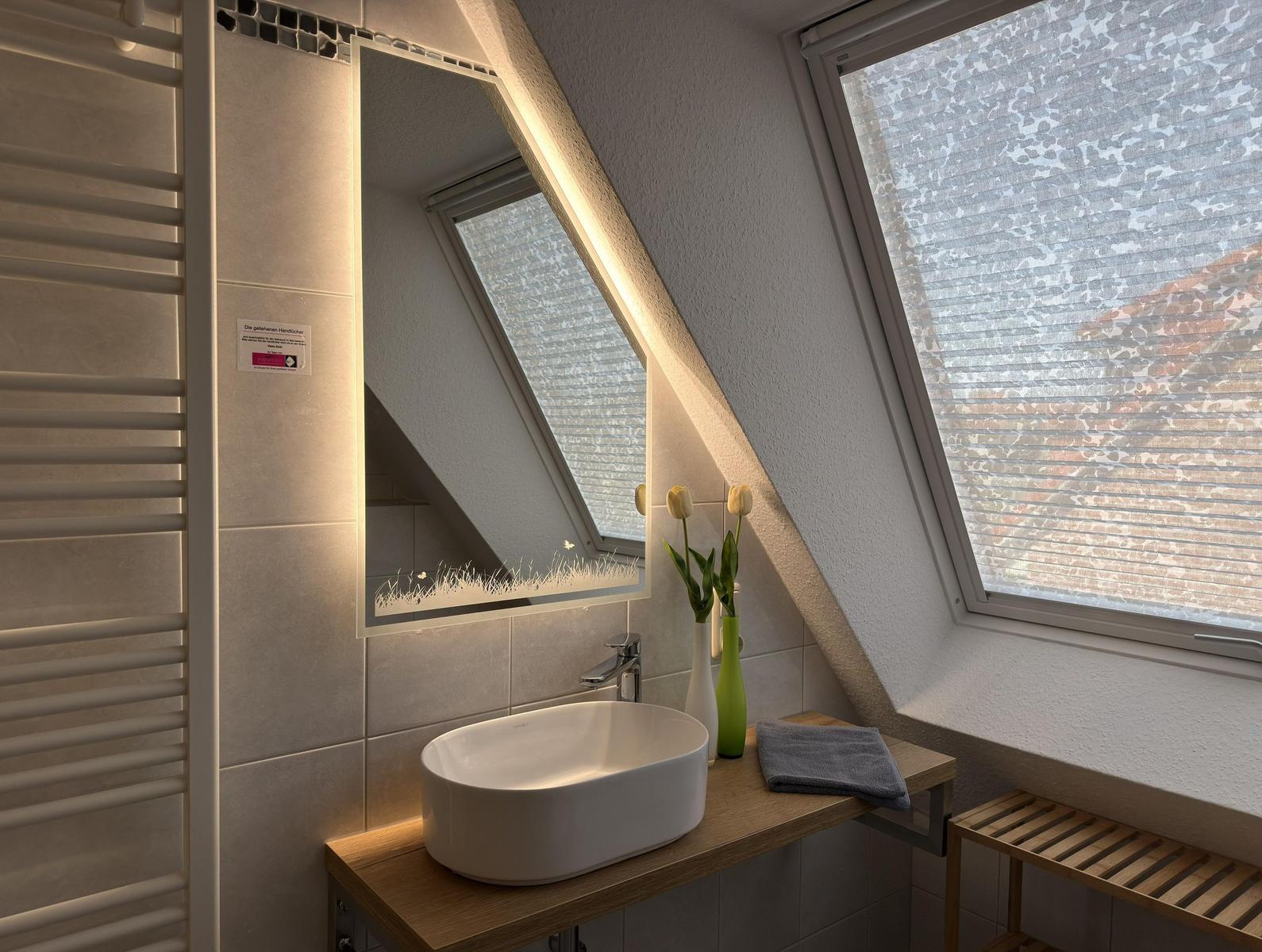 Badezimmer mit Waschtisch, Spiegel und Dachfenster